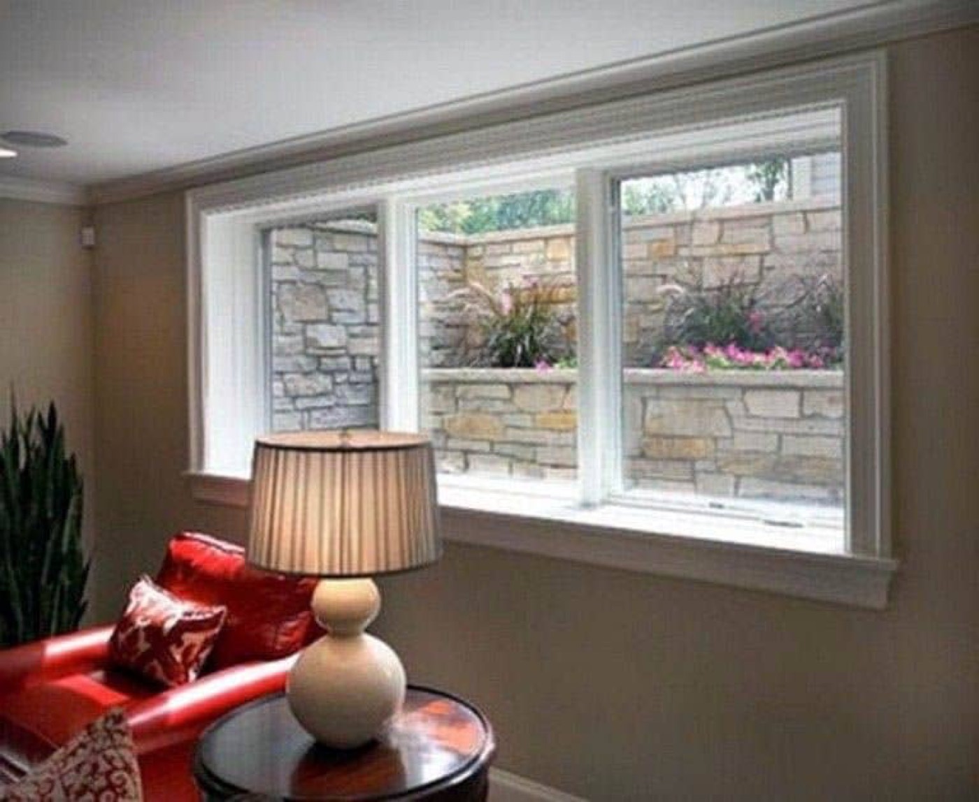 The view from inside a room onto a window well faced with a dry stone wall